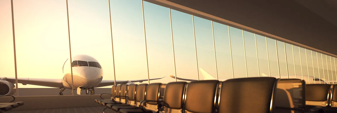 Vue d'un avion à travers les vitres d'une salle d'embarquement à l'aéroport. Des rangées de sièges vides se trouvent au premier plan, symbolisant l'attente avant le départ pour un voyage d'affaires, mis en avant par une agence de voyages d'affaires à Toulouse.