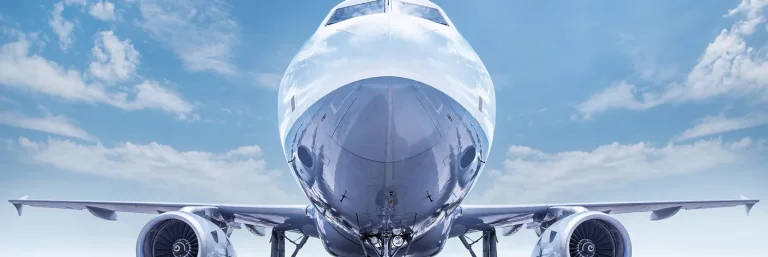 Vue de face d'un avion prêt à décoller sous un ciel bleu. L'image symbolise la puissance et la fiabilité des voyages d'affaires, mettant en avant les services de CTA Business Travel pour organiser et gérer efficacement les déplacements professionnels.