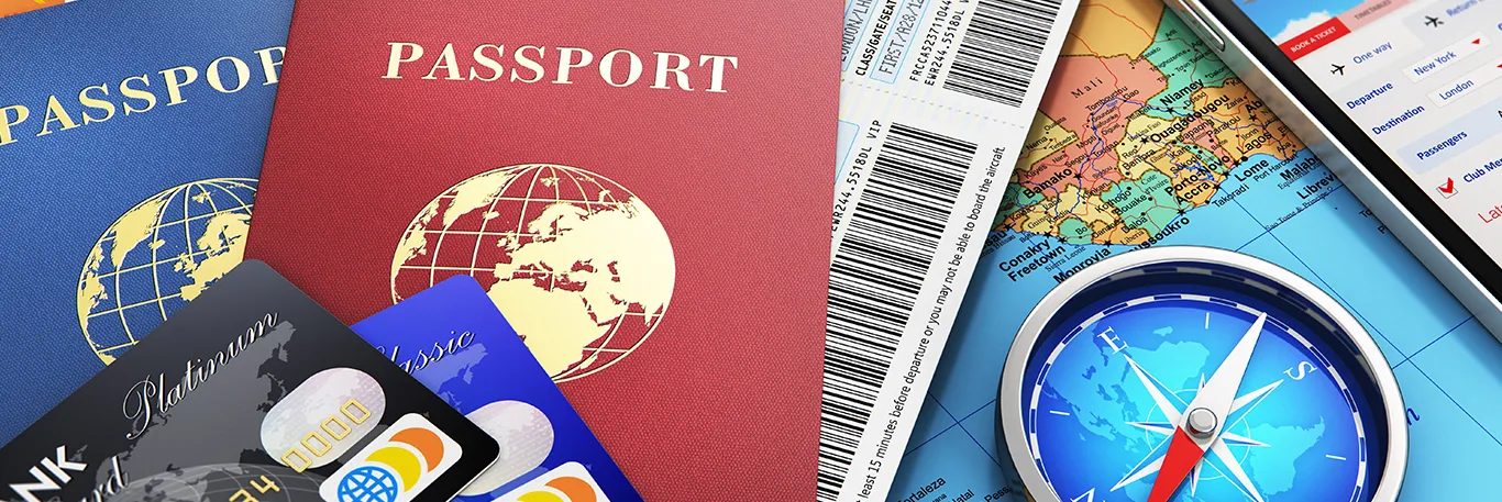 Passeports, cartes de crédit, billets d'avion, carte du monde et boussole. L'image représente les éléments essentiels pour l'organisation de voyages d'affaires, illustrant les services de CTA Business Travel pour une gestion complète et efficace des déplacements professionnels.