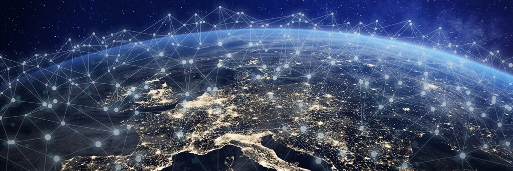 Vue de l'espace montrant une portion de la Terre, principalement l'Europe, illuminée par les lumières des villes la nuit, avec des lignes et des points interconnectés symbolisant un réseau mondial de communication. Cette image illustre le réseau mondial de TourCom, mettant en avant la connectivité et l'intégration des services de voyage d'affaires à travers le monde.