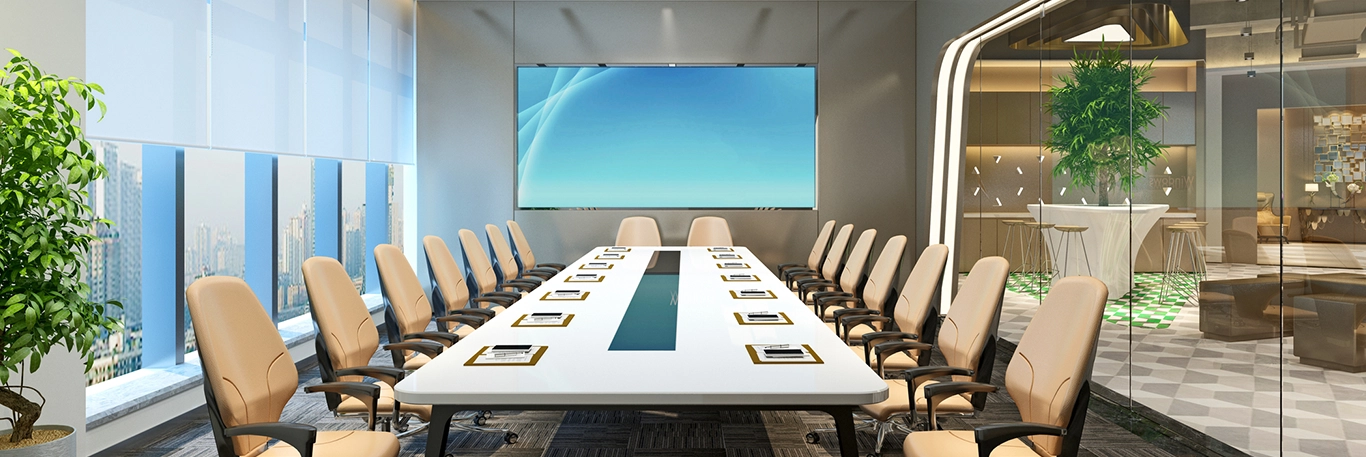 Une salle de conférence moderne et élégante avec une grande table rectangulaire entourée de chaises beige. Des tablettes et stylos sont placés sur la table pour chaque participant. Un grand écran est monté sur le mur au fond de la salle, et une baie vitrée offre une vue sur la ville et laisse entrer la lumière naturelle. Cette image illustre l'organisation de séminaires et de réunions professionnelles dans des espaces bien équipés et confortables, adaptés aux besoins des entreprises.