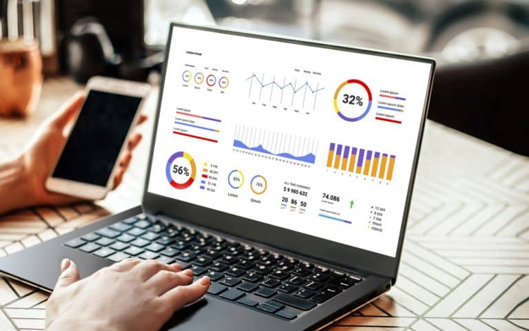 Une femme analyste travaille sur un ordinateur portable, montre des statistiques, des graphiques
